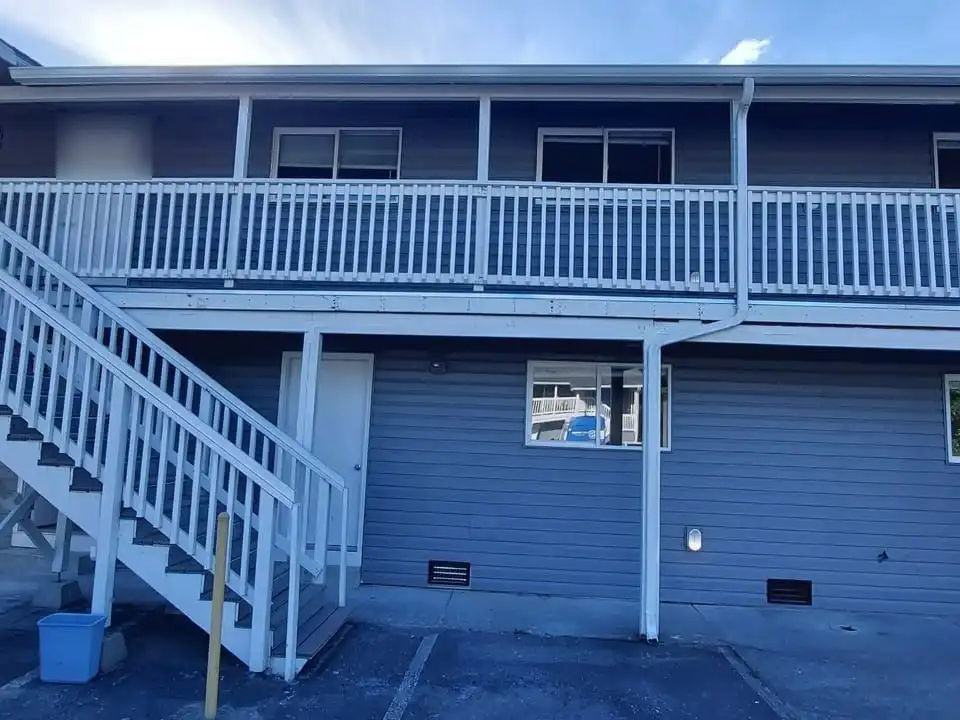 Two-story exterior stair and upper walkway with composite treads and white railings on an apartment building, Sedro-Woolley