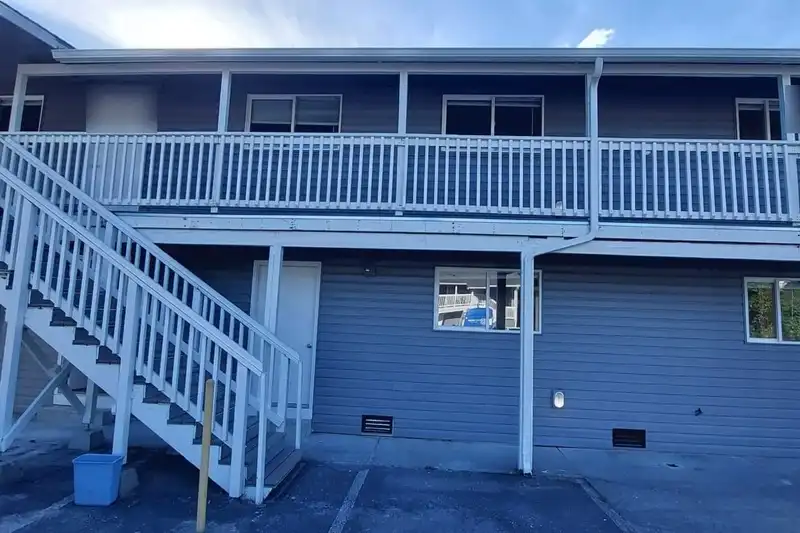 Two-story exterior stair and upper walkway with composite treads and white railings on an apartment building, Sedro-Woolley