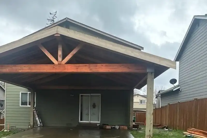 Gable patio cover with an exposed truss and glulam beam over a backyard patio, Marysville
